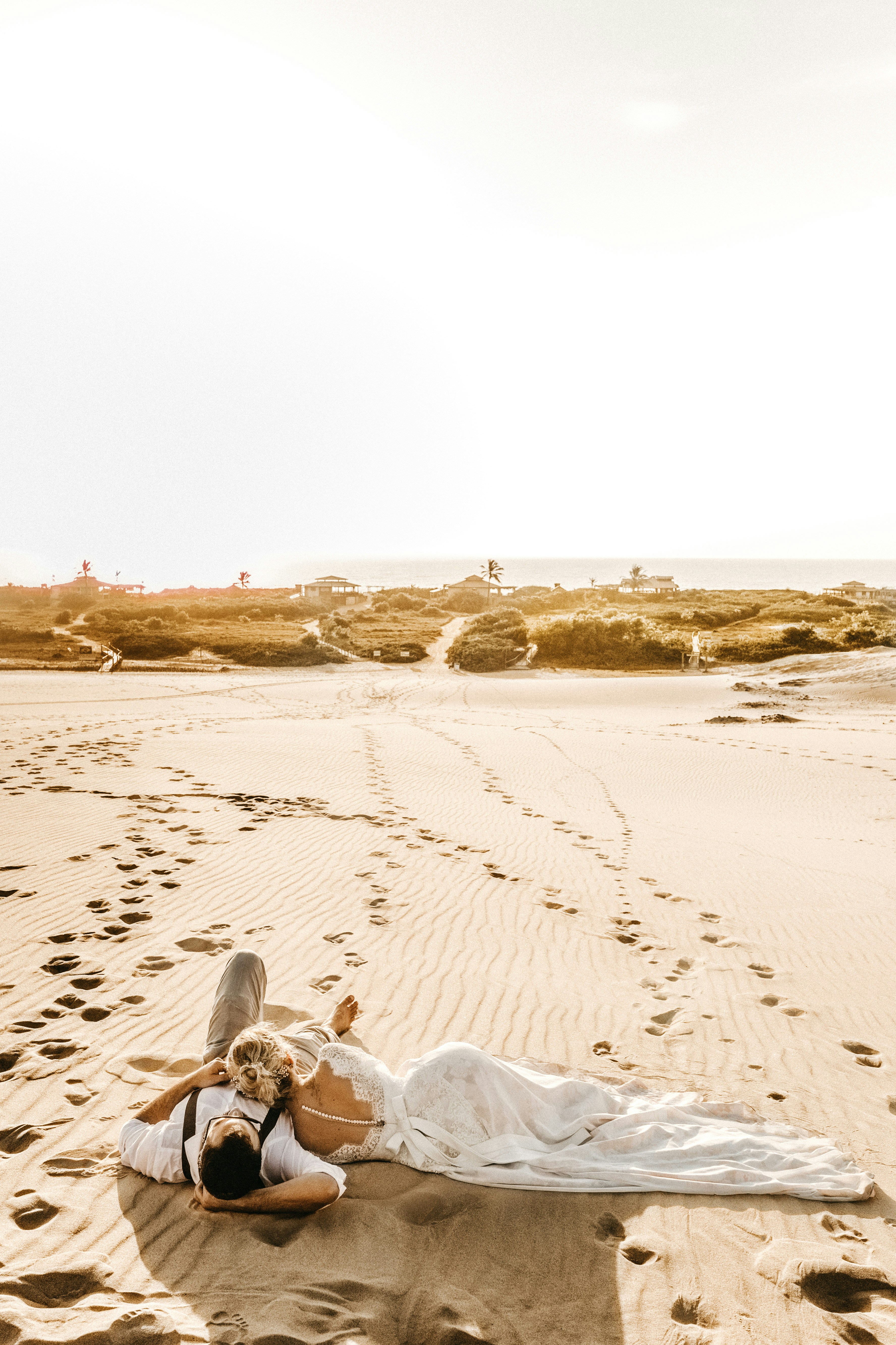 Expansive sandy beach with subtle footprints leading towards the horizon