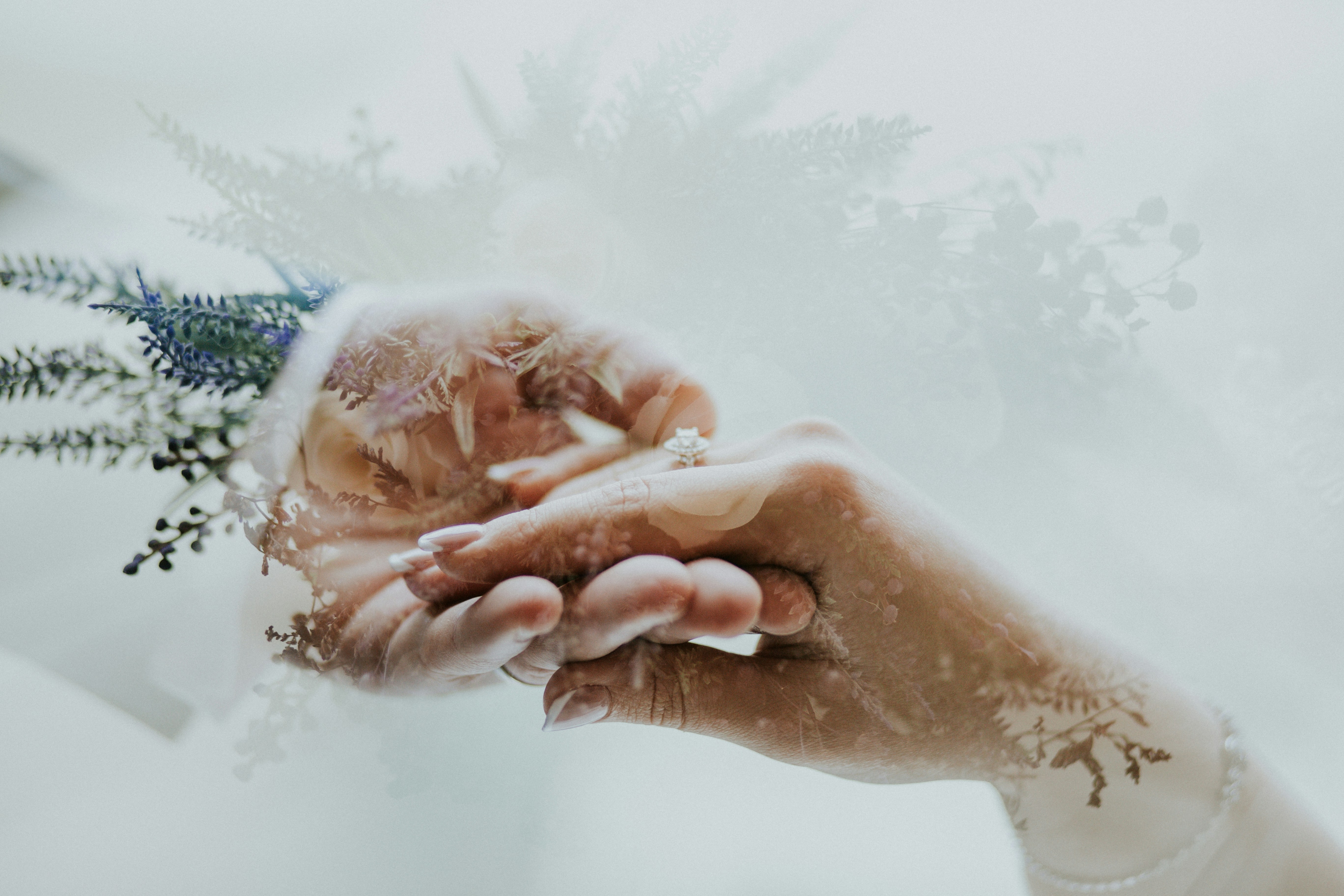 Close-up of two hands gently clasped, possibly with water or subtle textures